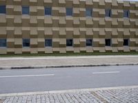 a man on a skateboard is riding next to the building and grass outside it
