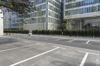 a sidewalk with trees and grass near a parking lot near a high - rise building