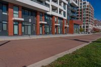 red and grey building on both sides of street with empty lot near by at top of walkway