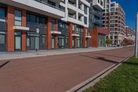 red and grey building on both sides of street with empty lot near by at top of walkway