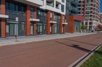 red and grey building on both sides of street with empty lot near by at top of walkway