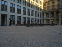 a courtyard with a building on the other side and a large white building with many windows