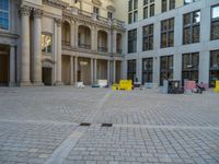 a courtyard with a building on the other side and a large white building with many windows