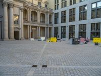 a courtyard with a building on the other side and a large white building with many windows