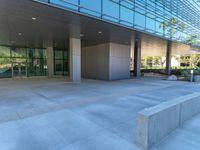 two grey blocks sitting next to a tall building on a sidewalk in front of grass