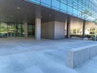 two grey blocks sitting next to a tall building on a sidewalk in front of grass