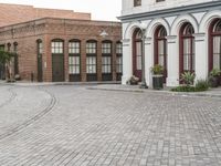 a street with old buildings and a bike parked on the brick pavements in front of it