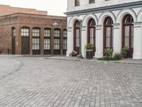 a street with old buildings and a bike parked on the brick pavements in front of it