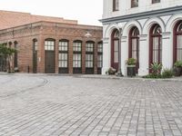 a street with old buildings and a bike parked on the brick pavements in front of it