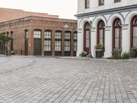 a street with old buildings and a bike parked on the brick pavements in front of it