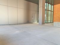 two grey blocks sitting next to a tall building on a sidewalk in front of grass