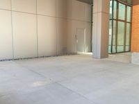 two grey blocks sitting next to a tall building on a sidewalk in front of grass