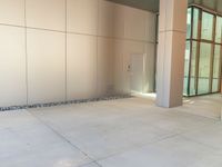 two grey blocks sitting next to a tall building on a sidewalk in front of grass