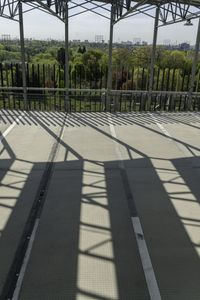 an outdoor metal structure with benches at the top and trees below it, and over the stairs are buildings