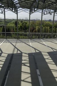 an outdoor metal structure with benches at the top and trees below it, and over the stairs are buildings