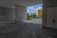 a white door is open in a empty building where there are parking spaces underneath the building