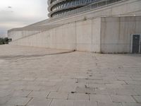 a black fire hydrant is sitting in the concrete area in front of a large building