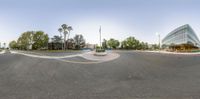 a large circle on an empty road next to trees and buildings and an intersection with the intersection painted orange