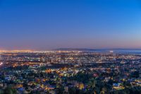 a view of an intersection at night from a hilltop overlooking the city skyline in hollywood