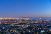 a view of an intersection at night from a hilltop overlooking the city skyline in hollywood