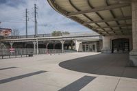 an empty public park with benches and people riding skateboards on the boardwalk at the train station