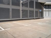 parking space with fence, metal walls, and gated area for cars to pass through