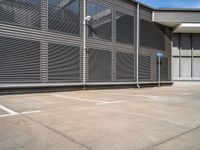 parking space with fence, metal walls, and gated area for cars to pass through