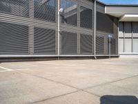 parking space with fence, metal walls, and gated area for cars to pass through