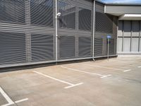 parking space with fence, metal walls, and gated area for cars to pass through