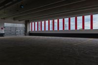 there are red and white striped stripes in the parking garage area of an empty warehouse