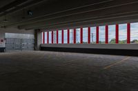 there are red and white striped stripes in the parking garage area of an empty warehouse