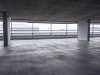 an empty parking garage with big window and traffic signs on the walls, overlooking the street below