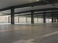 a parking garage that has white painted flooring and yellow line drawn in between two rows