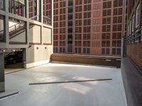 a parking garage in between two brick buildings, with a few pieces of wood stuck out of the floor