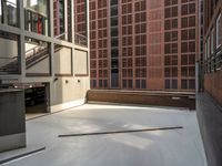 a parking garage in between two brick buildings, with a few pieces of wood stuck out of the floor