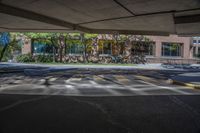 a parking garage with cars parked on the lot in front of it and buildings behind