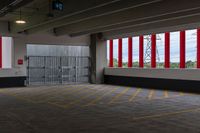 the sun shines on this large parking garage space inside a building with large red and white striped doors