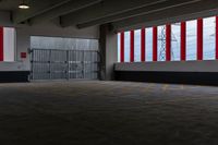 the sun shines on this large parking garage space inside a building with large red and white striped doors