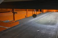 an underground parking lot with metal grate in the center and three sinks at the bottom