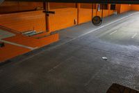 an underground parking lot with metal grate in the center and three sinks at the bottom