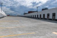 this is an empty industrial building and parking lot under clouds, with no one visible