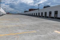 this is an empty industrial building and parking lot under clouds, with no one visible