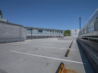 an empty parking lot with several metal barriers on it and a street in the back