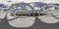 a fish eye lens reflects a parking lot in the city while the sun shines