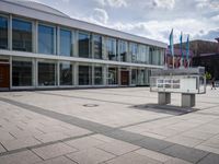 a large open building that has several flags on it's sides and two benches at the end