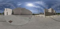 a fish eye view of a skateboard park with a skateboard ramp and a skate park in the background