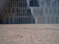 a white building with several steps and large glass panels in the facade is a mosaic that depicts a man