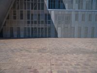 a white building with several steps and large glass panels in the facade is a mosaic that depicts a man