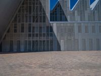 a white building with several steps and large glass panels in the facade is a mosaic that depicts a man