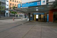 people walking in and out of a bus station with signs on the top and bottom